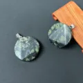 Detailansicht von runden Naturkristallstein-Anhängern mit Metallösen und facettiertem Design. - Vogelstein