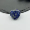 Close-up detail of natural blue lapis lazuli gemstone heart pendant with silver jump ring. - Lapis Lazuli