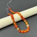 Close-up detail of natural gemstone heart-shaped agate beads for DIY jewelry making. - Red Agate Strand