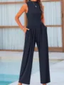 Detailed view of the sleeveless wide-leg jumpsuit with pockets, elegant outdoor pool setting. - XS / Jumpsuits / Navy Blue