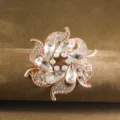 Stunning detail view of a glittering crystal flower brooch with rose gold tone finish. - White