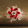 Detailed view of elegant flower brooch pin with red rhinestones and sparkling crystals for women - Red