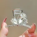 Close-up detail of silver crystal bow hair claw clip, sparkling rhinestones for elegant styling. - Silver White Stone