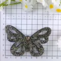 Rhinestone butterfly patch detail view on measuring grid, sparkly DIY shoe and hair accessory. - Black