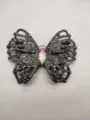 Close-up detail of butterfly rhinestone jewelry accessory with sparkling crystal gems. - Gray