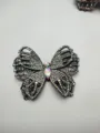 Close-up detail of sparkling rhinestone butterfly patch, sparkling crystal clothing accessory. - White