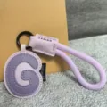 Close-up of a light purple leather letter G keychain pendant with a matching braided strap. - Letter G