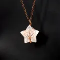 Close-up detail of a handmade wire-wrapped life tree star crystal pendant necklace. - Antique Copper + Clear Quartz