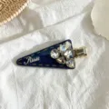 Gros plan de la pince à cheveux triangulaire en strass scintillants avec design en tissu. - Pince Triangle Strass / Bleu