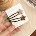 Vue detaillee de pinces a cheveux etoile a pois marron et rose sur carte de presentation. - Paire de Pinces à Cheveux Étoile Pois / Rose Café