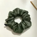 Gros plan détaillé de chouchou en satin vert foncé, montrant une texture plissée élégante. - Vert olive