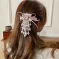 Gros plan sur la pince à cheveux coréenne nœud papillon perles cœur avec glands suspendus. - Barrette à Cheveux Nœud Glands de Perles / Rose