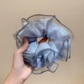 Gros plan détaillé du chouchou en organza bleu clair avec une texture brillante. - Bleu clair