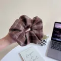 Vue détaillée de l'élastique à cheveux à carreaux marron, montrant sa texture rétro. - S / Café