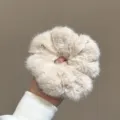 Vue détaillée d'un chouchou en peluche duveteuse avec perles, doux pour coiffures élégantes. - Blanc Cassé