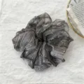 Primer plano detallado de un coletero de malla gris oscuro con lunares blancos. - Negro