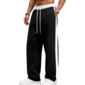 Close-up detail of casual black wide-leg sweatpants featuring a contrasting white side stripe. - S / Bottoms / Black