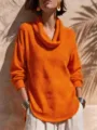 Nahaufnahme Detail des leuchtend orangefarbenen Pullovers mit Wasserfallkragen und Saum. - Orangerot
