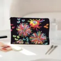 Close-up detail van de stijlvolle zwarte cosmetische tas met levendige 3D bloemenprint. - Abstrakt Bloemen