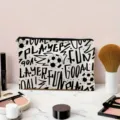 Gedetailleerd overzicht van zwart-wit canvas make-uptas met trendy voetbal- en graffitiprint. - Voetbalpatroon (01)