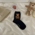 Black mid-tube socks featuring a cute 3D plush teddy bear patch and soft cotton fabric. - Black
