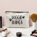 Detailed close-up view of a canvas zipper makeup bag featuring a cute paw print design. - Off-White (DOGGIE THINGS Print)