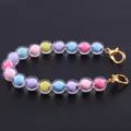 Dettaglio del braccialetto di perline colorate da 10 mm con sfere trasparenti e moschettoni dorati. - Macaron 2