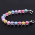 Dettaglio ravvicinato del bracciale di perle in resina colorata da 10mm con chiusure metalliche. - Macaron