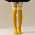 Close-up detail of yellow over-the-knee thigh high socks with triple white stripes. - One Size / Ginger with White Stripes