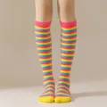 Detalle de calcetines altos a rayas de colores con diseño en rosa, amarillo y azul. - Puño Amarillo Azul Rosa