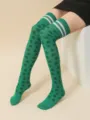 Detalle en primer plano de calcetines altos verdes con rayas blancas y motivos de trébol. - Calcetines de Trébol de Doble Tallo