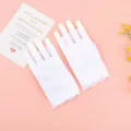 Detalle de guantes de encaje blanco sin dedos elegantes presentados en fondo rosa. - Talla única / Blanco