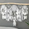 Close-up of handmade white feather dream catcher wall hanging with delicate lace details. - White