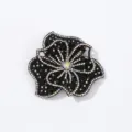 Close up detail of sparkling rhinestone flower patch, black fabric backing DIY craft accessory. - Black