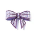 Detailed close-up of a purple rhinestone and pearl bow shoe clip accessory, elegant. - Purple