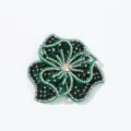 Detailed close-up of green rhinestone flower applique, sparkling crystal fabric patch. - Dark Green