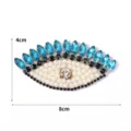 Detailansicht des glitzernden Strass-Perlen-Böse-Blick-Perlenaufnähers für Kleidung. - Blaues Auge