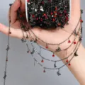 Primo piano dettagliato della catena nera DIY con strass rossi e graziosi ciondoli a farfalla. - Nero Pistola