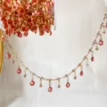 Primo piano dettaglio catena frangia strass vetro rosa, componenti accessori rame. - Oro KC