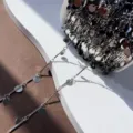 Dettaglio di catena argentata con barretta dritta e dischi rotondi per accessori di gioielli DIY. - K bianco