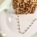 Primo piano dettagliato di una catena di strass dorata per gioielli fai da te su piatto. - Oro KC con strass bianchi