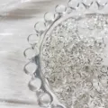 Detail shot of silver jump rings in glass dish, perfect for DIY jewelry making and handmade chains. - 7x4mm / Bright Silver