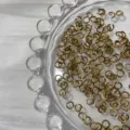 Gros plan sur des anneaux de saut dorés, accessoire de bijouterie DIY essentiel pour chaînes. - Laiton