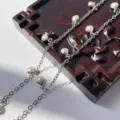 Dettaglio ravvicinato di catena in rame con perle da 4mm per accessori per capelli fai da te. - K bianco