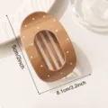Caramel brown oval hair claw clip with white polka dots, retro minimalist hair accessory style. - Brown