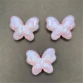Gros plan détaillé de breloques papillon en acrylique pailleté rose pour loisirs créatifs. - Mauve Clair