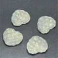 Vista detallada de cuentas de corazón con gofre y purpurina, ideales para joyería y dijes DIY. - Blanco