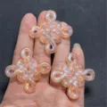 Close-up detail shot of iridescent resin Chinese knot DIY charms with glitter finish. - Orange