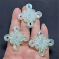 Close-up detail of iridescent luminous Chinese knot resin DIY craft charms and accessories. - Light Green