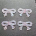 Close-up detail of translucent pink bow resin DIY beads with star tails, perfect for phone charms. - Light Pink